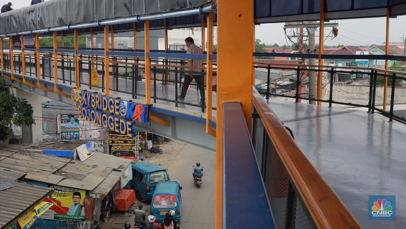 Warga berjalan di area Skybridge Bojonggede di Kabupaten Bogor, Jawa Barat, Rabu, (6/12/2023). Skybridge ini mulai dibuka untuk uji coba 6-7 Desember 2023. Skybridge ini menghubungkan terminal dengan Stasiun Bojonggede. (CNBC Indonesia/Muhammad Sabki)
