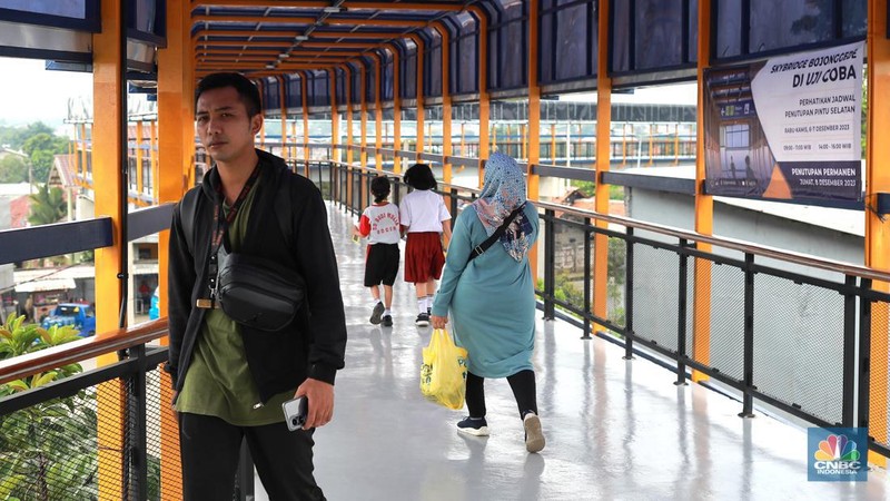 Warga berjalan di area Skybridge Bojonggede di Kabupaten Bogor, Jawa Barat, Rabu, (6/12/2023). Skybridge ini mulai dibuka untuk uji coba 6-7 Desember 2023. Skybridge ini menghubungkan terminal dengan Stasiun Bojonggede. (CNBC Indonesia/Muhammad Sabki)