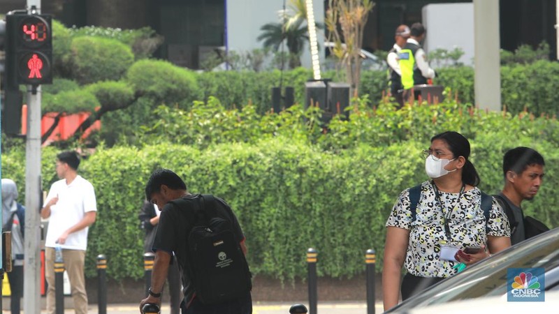 Pekerja memakai masker saat beraktivitas di Pedestrian Kawasan Bundaran HI, Jalan Sudirman-Thamrin, Jakarta, Kamis (7/12/2023). (CNBC Indonesia/Muhammad Sabki)