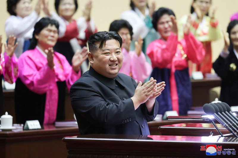Pemimpin Korea Utara Kim Jong Un dan pendukungnya bertepuk tangan pada Pertemuan Nasional Para Ibu ke-5 di Pyongyang dalam gambar yang dirilis oleh Kantor Berita Pusat Korea pada 5 Desember 2023. (KCNA via REUTERS)