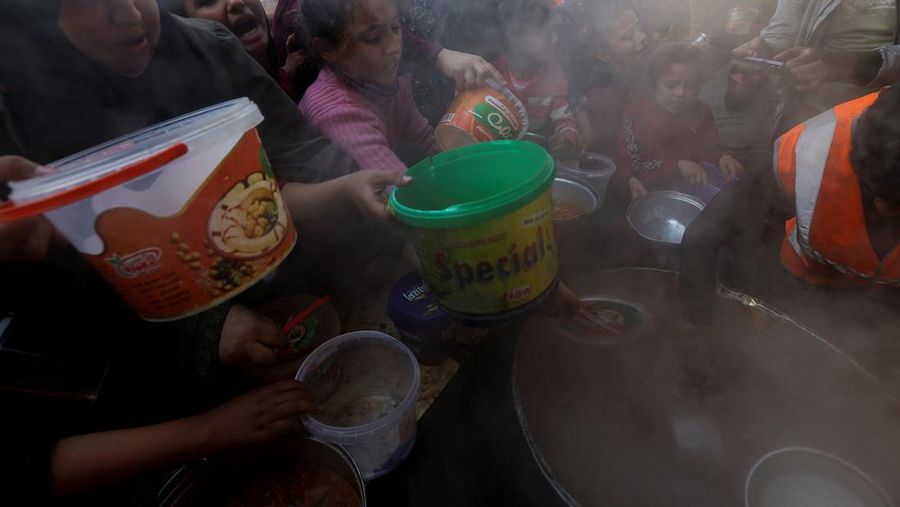 Warga Palestina berebut makanan yang diberikan oleh para sukarelawan, di tengah kekurangan pangan selama konflik antara Israel dan kelompok Islam Palestina Hamas berlanjut, di Rafah, di selatan Jalur Gaza. (REUTERS/Ibraheem Abu Mustafa)