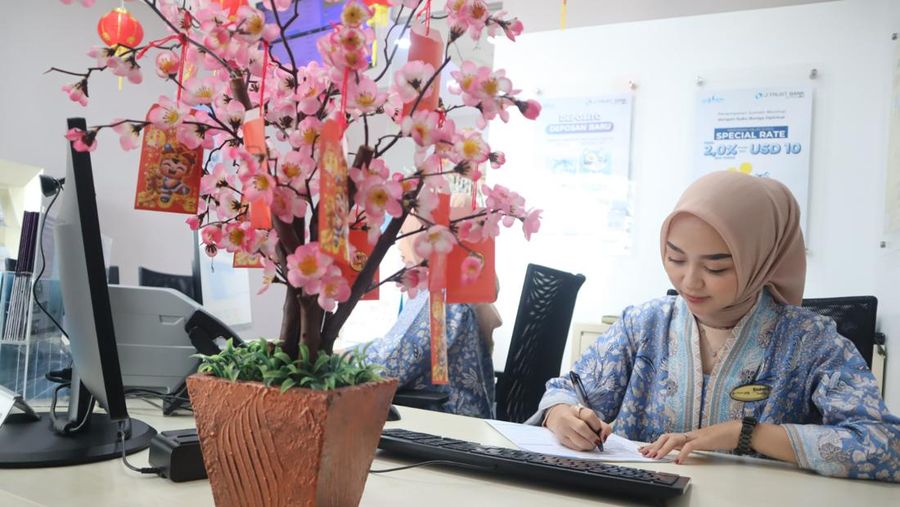 Staf J Trust Bank tengah melakukan aktivitas perbankan.