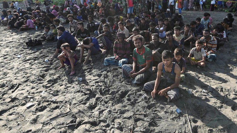 Warga memeriksa perahu kayu yang membawa Muslim Rohingya, setelah mendarat di Blang Ulam, provinsi Aceh, Indonesia, 10 Desember 2023. (REUTERS/Riska Munawarah)     TPX IMAGES OF THE DAY