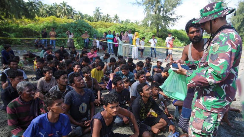 Warga memeriksa perahu kayu yang membawa Muslim Rohingya, setelah mendarat di Blang Ulam, provinsi Aceh, Indonesia, 10 Desember 2023. (REUTERS/Riska Munawarah)     TPX IMAGES OF THE DAY