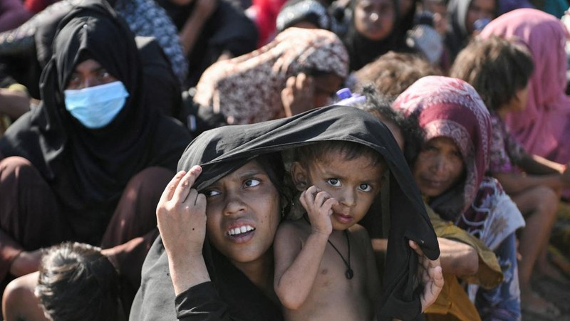 Warga memeriksa perahu kayu yang membawa Muslim Rohingya, setelah mendarat di Blang Ulam, provinsi Aceh, Indonesia, 10 Desember 2023. (REUTERS/Riska Munawarah)     TPX IMAGES OF THE DAY