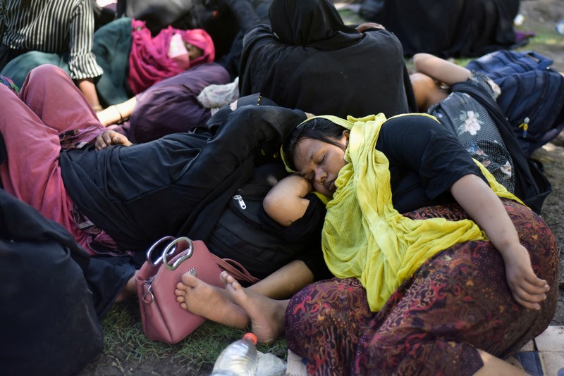 Warga memeriksa perahu kayu yang membawa Muslim Rohingya, setelah mendarat di Blang Ulam, provinsi Aceh, Indonesia, 10 Desember 2023. (REUTERS/Riska Munawarah)     TPX IMAGES OF THE DAY