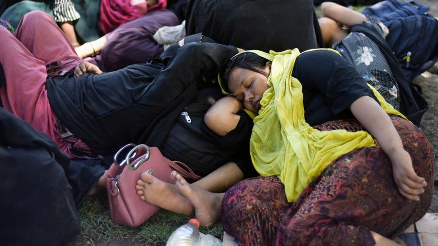 Warga memeriksa perahu kayu yang membawa Muslim Rohingya, setelah mendarat di Blang Ulam, provinsi Aceh, Indonesia, 10 Desember 2023. (REUTERS/Riska Munawarah)     TPX IMAGES OF THE DAY