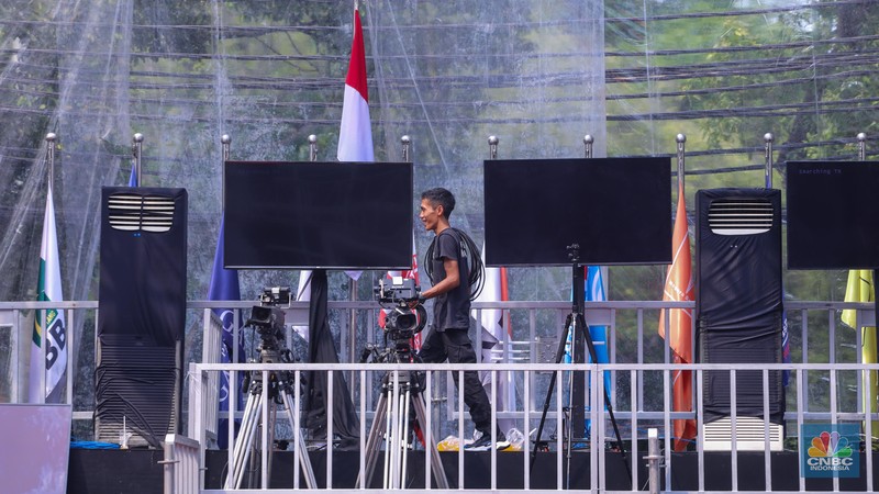 Sejumlah pekerja menyelesaikan dekorasi untuk kegiatan debat Calon Presiden (Capres) di halaman kantor Komisi Pemilihan Umum (KPU) RI, Jakarta, Senin (11/12/2023). (CNBC Indonesia/Faisal Rahman)