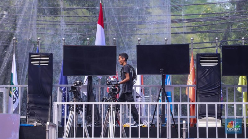 Sejumlah pekerja menyelesaikan dekorasi untuk kegiatan debat Calon Presiden (Capres) di halaman kantor Komisi Pemilihan Umum (KPU) RI, Jakarta, Senin (11/12/2023). (CNBC Indonesia/Faisal Rahman)