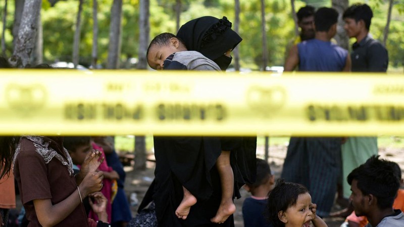 Warga memeriksa perahu kayu yang membawa Muslim Rohingya, setelah mendarat di Blang Ulam, provinsi Aceh, Indonesia, 10 Desember 2023. (REUTERS/Riska Munawarah)     TPX IMAGES OF THE DAY