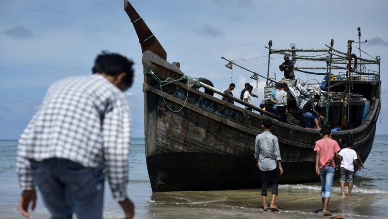 Warga memeriksa perahu kayu yang membawa Muslim Rohingya, setelah mendarat di Blang Ulam, provinsi Aceh, Indonesia, 10 Desember 2023. (REUTERS/Riska Munawarah)     TPX IMAGES OF THE DAY
