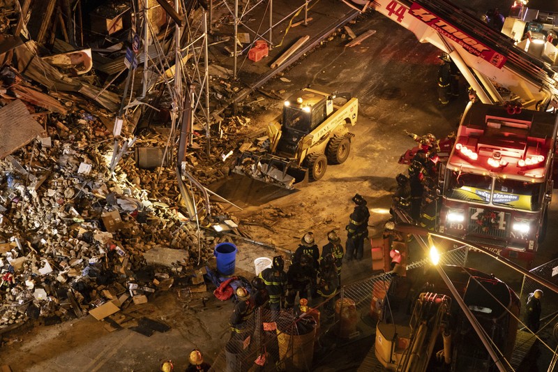 Debris piles up after a building collapsed in the Bronx borough of New York, Monday, Dec. 11, 2023. (AP Photo/Yuki Iwamura)