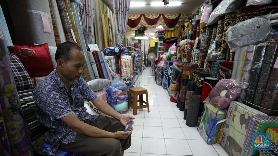 Sejumlah warga menyaksikan debat calon presiden di  Pasar Kebayoran Lama, Jakarta, Selasa (12/12/2023). (CNBC Indonesia/Tri Susilo)