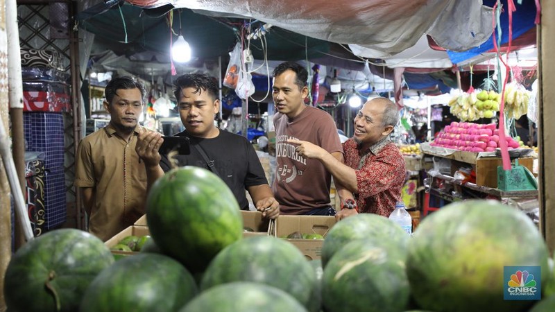 Sejumlah warga menyaksikan debat calon presiden di  Pasar Kebayoran Lama, Jakarta, Selasa (12/12/2023). (CNBC Indonesia/Tri Susilo)