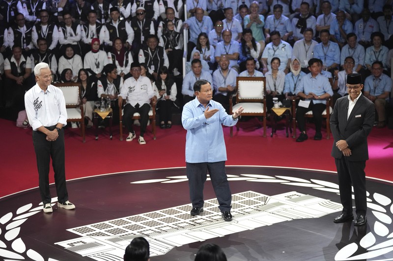 Indonesia Election Presidential candidate Prabowo Subianto, center, speaks as other candidates Ganjar Pranowo, left, and Anies Baswedan react during the presidential candidates' debate in Jakarta, Indonesia, Tuesday, Dec. 12, 2023. (AP Photo/Tatan Syuflana)