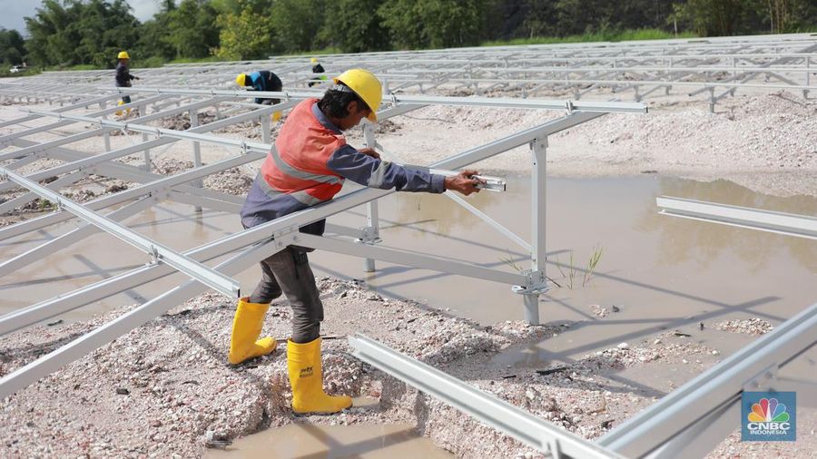 Pekerja menyelesaikan Proyek Pembangkit listrik tenaga surya pada fasilitas pemuatan tongkang di jetty senyiur. (CNBC Indonesia/Muhamad Sabki)