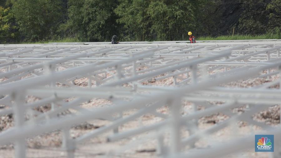 Pekerja menyelesaikan Proyek Pembangkit listrik tenaga surya pada fasilitas pemuatan tongkang di jetty senyiur. (CNBC Indonesia/Muhamad Sabki)