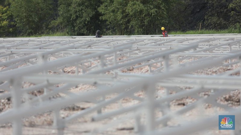 Pekerja menyelesaikan Proyek Pembangkit listrik tenaga surya pada fasilitas pemuatan tongkang di jetty senyiur. (CNBC Indonesia/Muhamad Sabki)