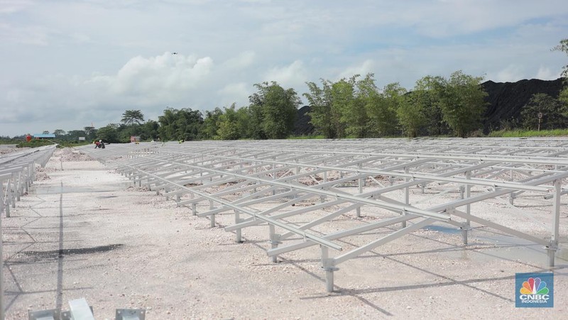 Pekerja menyelesaikan Proyek Pembangkit listrik tenaga surya pada fasilitas pemuatan tongkang di jetty senyiur. (CNBC Indonesia/Muhamad Sabki)