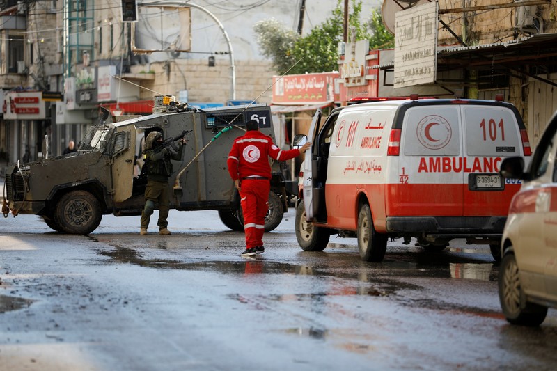 Kendaraan militer Israel memblokir ambulans di jalan selama penggerebekan di Jenin, di tengah konflik yang sedang berlangsung antara Israel dan kelompok Islam Palestina Hamas, di Tepi Barat yang diduduki Israel, 13 Desember 2023. Kendaraan militer Israel memblokir ambulans di jalan selama penggerebekan di Jenin, di tengah konflik yang sedang berlangsung antara Israel dan kelompok Islam Palestina Hamas, di Tepi Barat yang diduduki Israel, 13 Desember 2023. (REUTERS/Raneen Sawafta)