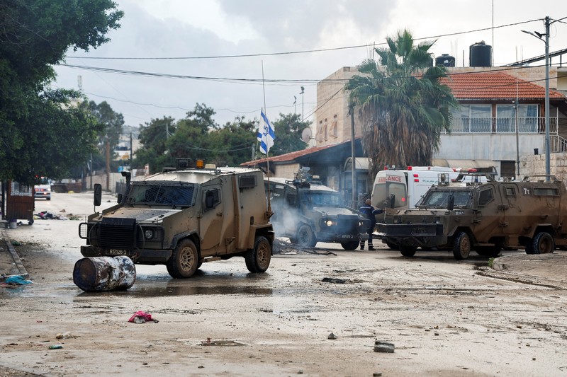 Kendaraan militer Israel memblokir ambulans di jalan selama penggerebekan di Jenin, di tengah konflik yang sedang berlangsung antara Israel dan kelompok Islam Palestina Hamas, di Tepi Barat yang diduduki Israel, 13 Desember 2023. Kendaraan militer Israel memblokir ambulans di jalan selama penggerebekan di Jenin, di tengah konflik yang sedang berlangsung antara Israel dan kelompok Islam Palestina Hamas, di Tepi Barat yang diduduki Israel, 13 Desember 2023. (REUTERS/Raneen Sawafta)