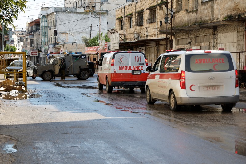Kendaraan militer Israel memblokir ambulans di jalan selama penggerebekan di Jenin, di tengah konflik yang sedang berlangsung antara Israel dan kelompok Islam Palestina Hamas, di Tepi Barat yang diduduki Israel, 13 Desember 2023. Kendaraan militer Israel memblokir ambulans di jalan selama penggerebekan di Jenin, di tengah konflik yang sedang berlangsung antara Israel dan kelompok Islam Palestina Hamas, di Tepi Barat yang diduduki Israel, 13 Desember 2023. (REUTERS/Raneen Sawafta)