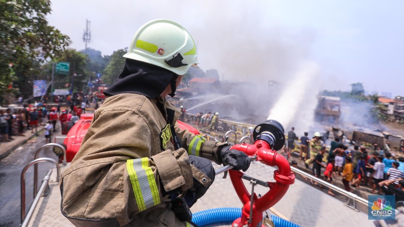 Petugas pemadam kebakaran memadamkan api yang membakar pekukiman padat di kawasan Manggarai, Tebet, Jakarta, Kamis (14/12/2023). (CNBC Indonesia/Faisal Rahman)