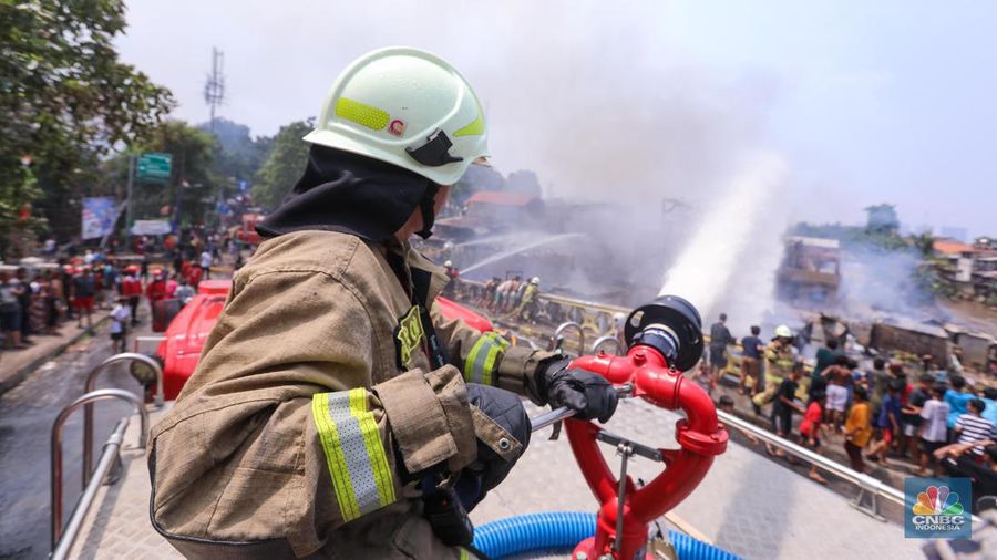 Petugas pemadam kebakaran memadamkan api yang membakar pekukiman padat di kawasan Manggarai, Tebet, Jakarta, Kamis (14/12/2023). (CNBC Indonesia/Faisal Rahman)