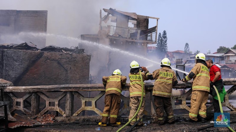 Petugas pemadam kebakaran memadamkan api yang membakar pekukiman padat di kawasan Manggarai, Tebet, Jakarta, Kamis (14/12/2023). (CNBC Indonesia/Faisal Rahman)