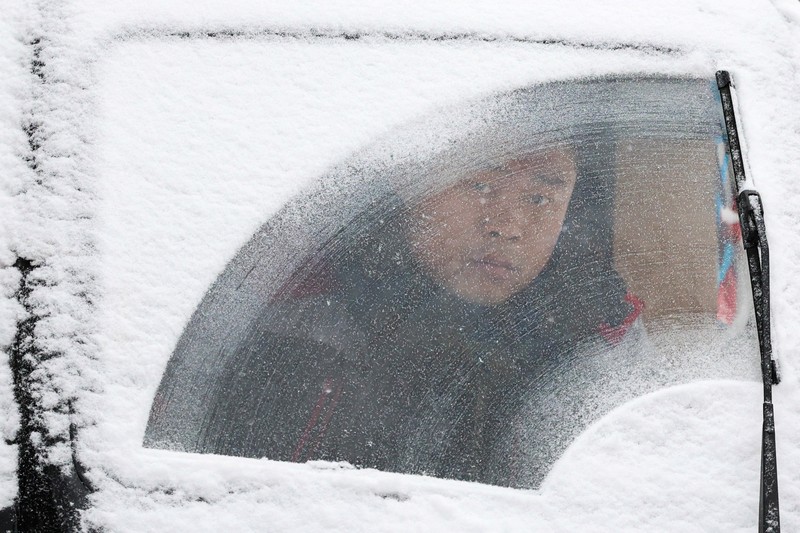 Orang-orang berjalan di jalan di tengah hujan salju di Beijing, Cina 13 Desember 2023. Orang-orang berjalan di jalan di tengah hujan salju di Beijing, Cina 13 Desember 2023. (REUTERS/Tingshu Wang)
