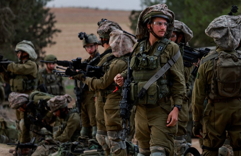 Tentara Israel berkumpul di sisi Israel dekat perbatasan dengan Gaza, di tengah konflik yang sedang berlangsung antara Israel dan kelompok Islam Palestina Hamas, terlihat dari Israel selatan, 12 Desember 2023. (REUTERS/Ammar Awad)