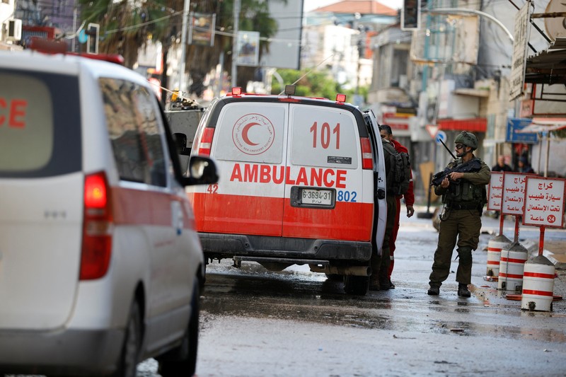 Kendaraan militer Israel memblokir ambulans di jalan selama penggerebekan di Jenin, di tengah konflik yang sedang berlangsung antara Israel dan kelompok Islam Palestina Hamas, di Tepi Barat yang diduduki Israel, 13 Desember 2023. Kendaraan militer Israel memblokir ambulans di jalan selama penggerebekan di Jenin, di tengah konflik yang sedang berlangsung antara Israel dan kelompok Islam Palestina Hamas, di Tepi Barat yang diduduki Israel, 13 Desember 2023. (REUTERS/Raneen Sawafta)