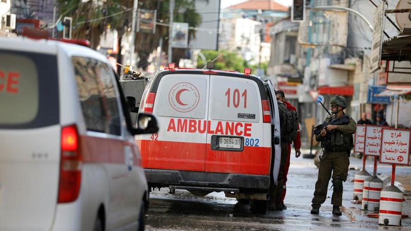 Kendaraan militer Israel memblokir ambulans di jalan selama penggerebekan di Jenin, di tengah konflik yang sedang berlangsung antara Israel dan kelompok Islam Palestina Hamas, di Tepi Barat yang diduduki Israel, 13 Desember 2023. (REUTERS/Raneen Sawafta)