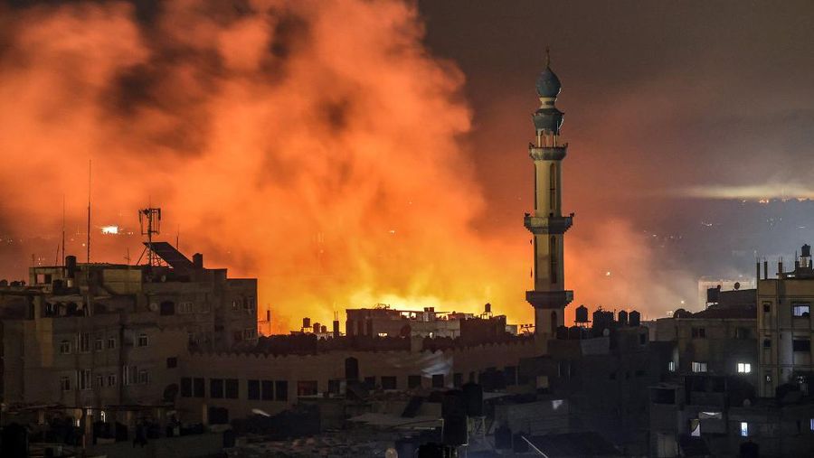 Api dan asap meletus setelah pemboman Israel di Rafah di Jalur Gaza selatan pada 14 Desember 2023, di tengah berlanjutnya pertempuran antara Israel dan kelompok militan Palestina Hamas. (Photo by MAHMUD HAMS / AFP)