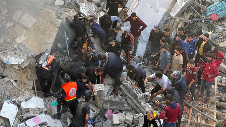Palestinians search for casualties at site of an Israeli strike on a house, amid the ongoing conflict between Israel and Palestinian Islamist group Hamas, in Rafah in the southern Gaza Strip December 14, 2023. REUTERS/Sami Abu Tabak