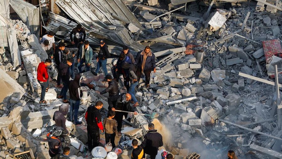 Palestinians inspect and clear rubble at the site of Israeli strikes on houses in Khan Younis, in the southern Gaza Strip December 14, 2023. REUTERS/Ibraheem Abu Mustafa