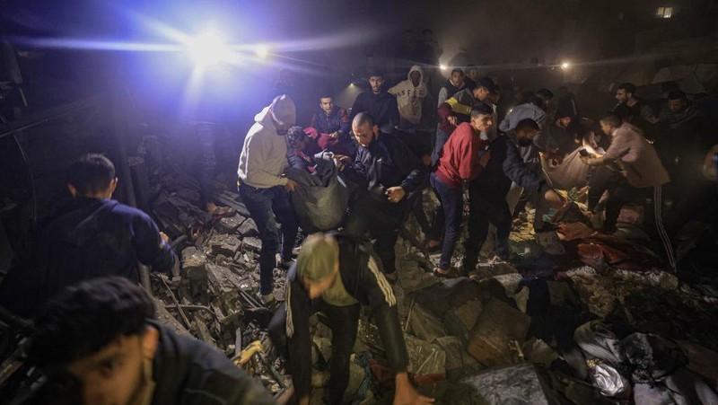 Api dan asap meletus setelah pemboman Israel di Rafah di Jalur Gaza selatan pada 14 Desember 2023, di tengah berlanjutnya pertempuran antara Israel dan kelompok militan Palestina Hamas. (Photo by MAHMUD HAMS / AFP)