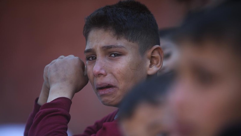 Warga memeriksa bangunan yang hancur usai pengeboman yang dilakukan oleh militer Israel di Rafah, Jalur Gaza Selatan, Jumat (15/12/2023). (SAID KHATIB / AFP)