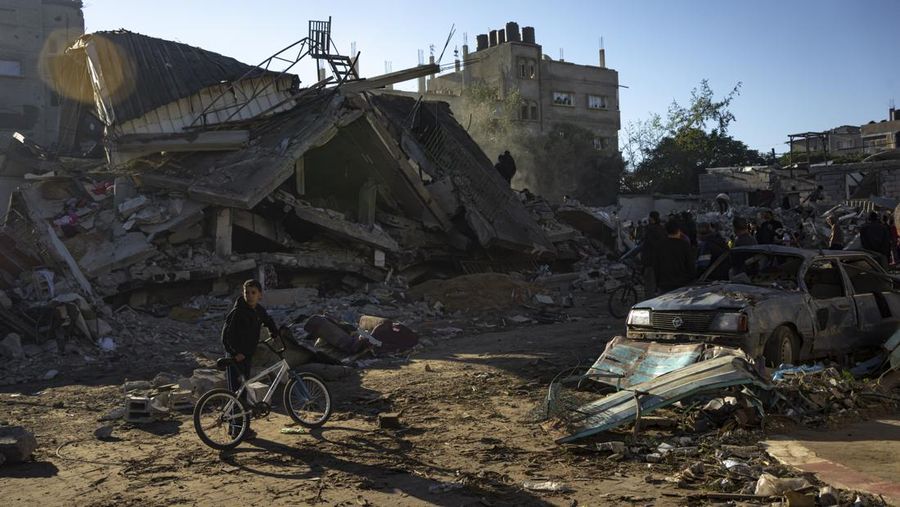 Warga memeriksa bangunan yang hancur usai pengeboman yang dilakukan oleh militer Israel di Rafah, Jalur Gaza Selatan, Jumat (15/12/2023). (SAID KHATIB / AFP)
