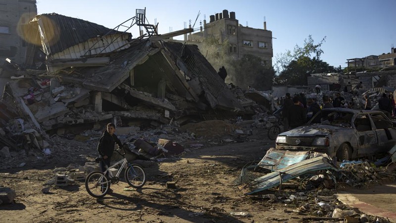 Warga memeriksa bangunan yang hancur usai pengeboman yang dilakukan oleh militer Israel di Rafah, Jalur Gaza Selatan, Jumat (15/12/2023). (SAID KHATIB / AFP)