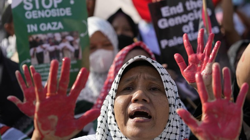 Sejumlah massa aksi membawa replika jenazah anak-anak saat melakukan unjuk rasa di depan Kedubes Amerika Serikat (AS), Jalan Medan Merdeka Selatan, Jakarta, Minggu (17/12/2023). (AP Photo/Achmad Ibrahim)