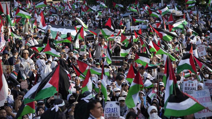 Sejumlah massa aksi membawa replika jenazah anak-anak saat melakukan unjuk rasa di depan Kedubes Amerika Serikat (AS), Jalan Medan Merdeka Selatan, Jakarta, Minggu (17/12/2023). (AP Photo/Achmad Ibrahim)