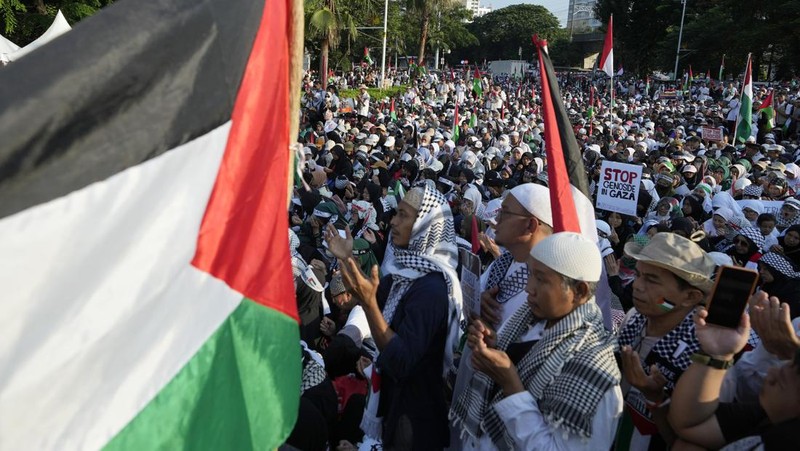 Sejumlah massa aksi membawa replika jenazah anak-anak saat melakukan unjuk rasa di depan Kedubes Amerika Serikat (AS), Jalan Medan Merdeka Selatan, Jakarta, Minggu (17/12/2023). (AP Photo/Achmad Ibrahim)