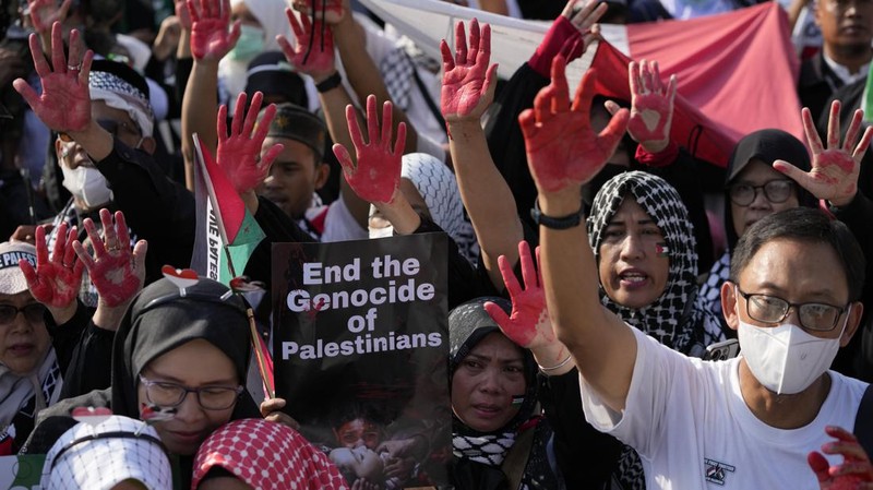 Sejumlah massa aksi membawa replika jenazah anak-anak saat melakukan unjuk rasa di depan Kedubes Amerika Serikat (AS), Jalan Medan Merdeka Selatan, Jakarta, Minggu (17/12/2023). (AP Photo/Achmad Ibrahim)
