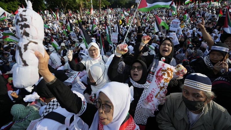 Sejumlah massa aksi membawa replika jenazah anak-anak saat melakukan unjuk rasa di depan Kedubes Amerika Serikat (AS), Jalan Medan Merdeka Selatan, Jakarta, Minggu (17/12/2023). (AP Photo/Achmad Ibrahim)