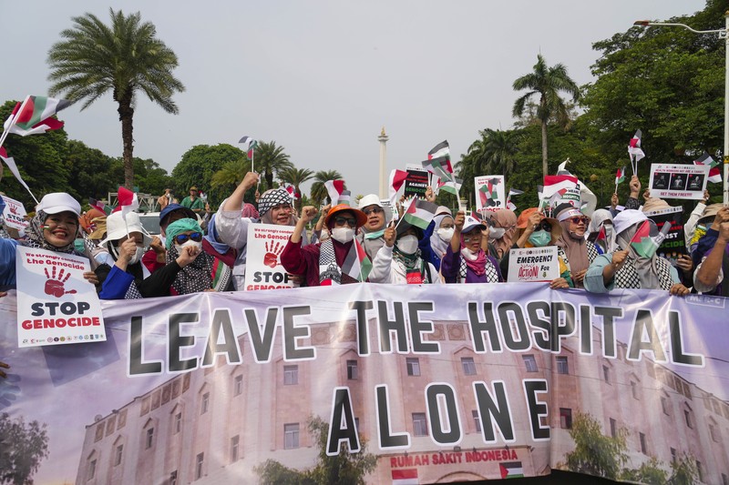 Sejumlah massa aksi membawa replika jenazah anak-anak saat melakukan unjuk rasa di depan Kedubes Amerika Serikat (AS), Jalan Medan Merdeka Selatan, Jakarta, Minggu (17/12/2023). (AP Photo/Achmad Ibrahim)