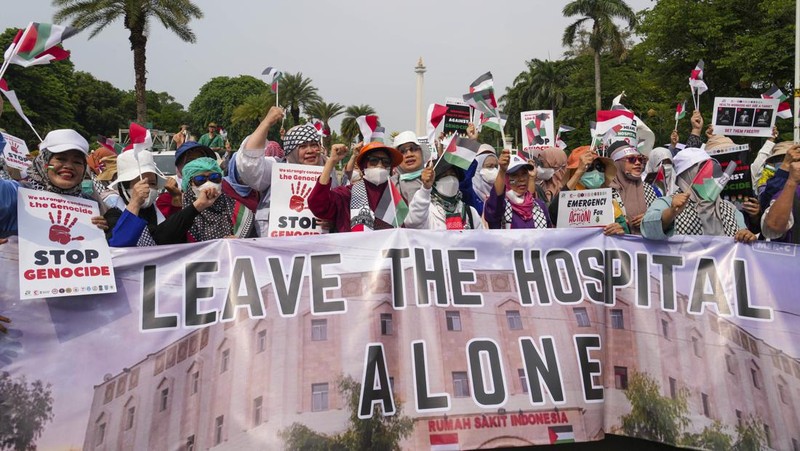 Sejumlah massa aksi membawa replika jenazah anak-anak saat melakukan unjuk rasa di depan Kedubes Amerika Serikat (AS), Jalan Medan Merdeka Selatan, Jakarta, Minggu (17/12/2023). (AP Photo/Achmad Ibrahim)