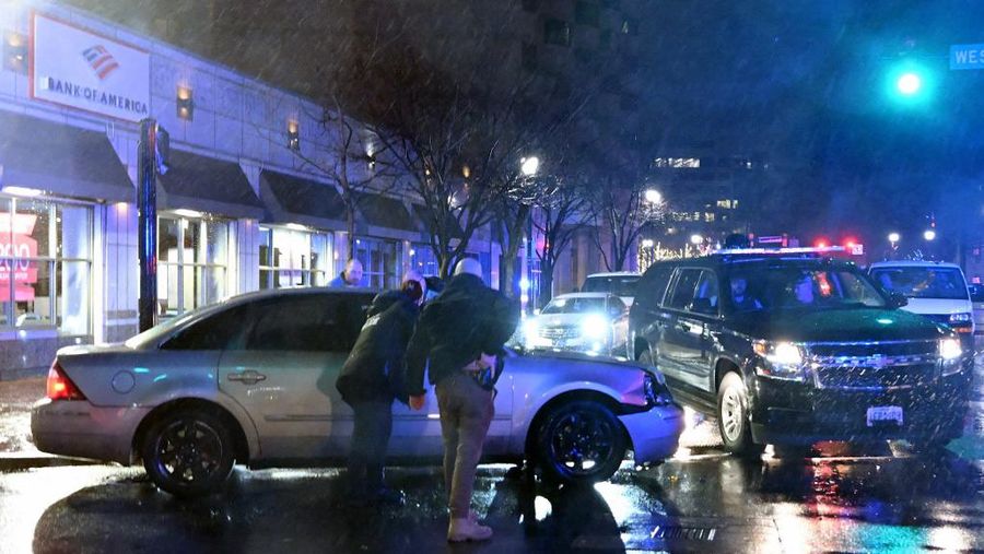 Anggota Dinas Rahasia AS bergegas menuju mobil, setelah menabrak iring-iringan mobil SUV, saat Presiden AS Joe Biden meninggalkan markas kampanyenya di Wilmington, Delaware pada 17 Desember 2023. (Photo by ANDREW CABALLERO-REYNOLDS / AFP)