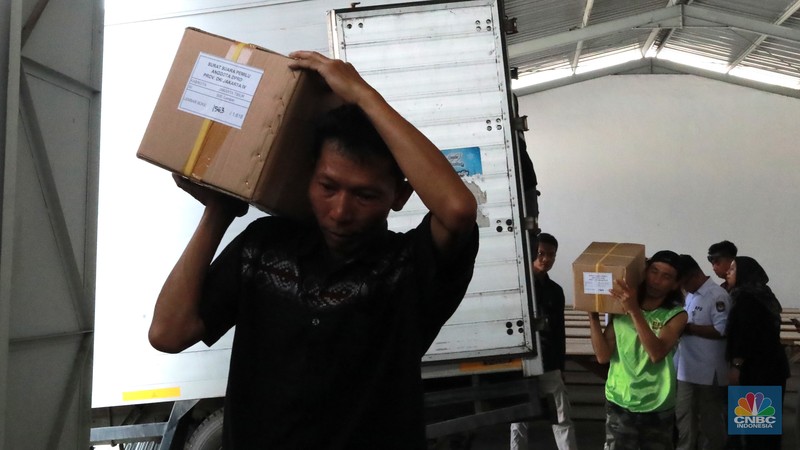 Seorang pekerja memindahkan kardus berisi surat suara Pemilu 2024 dari kontainer saat pendistribusian di gudang KPU Jakarta Timur, Kawasan Industri Pulogadung (JIEP) Jakarta Timur, Senin, (18/12/2023). (CNBC Indonesia/Muhammad Sabki)