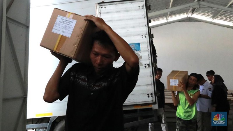 Seorang pekerja memindahkan kardus berisi surat suara Pemilu 2024 dari kontainer saat pendistribusian di gudang KPU Jakarta Timur, Kawasan Industri Pulogadung (JIEP) Jakarta Timur, Senin, (18/12/2023). (CNBC Indonesia/Muhammad Sabki)